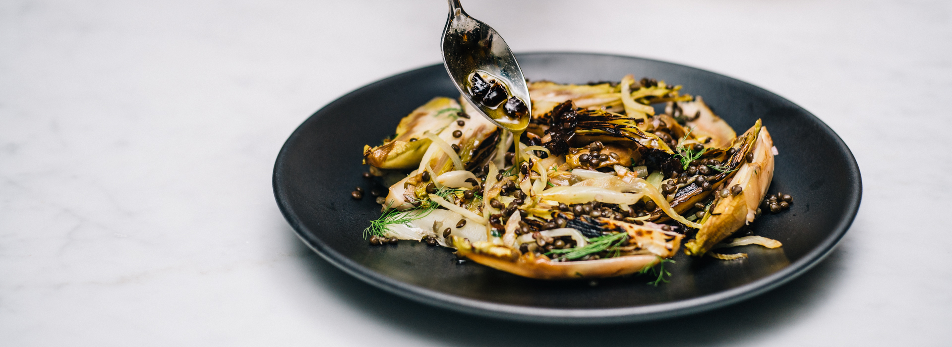 <p>Charring endive and fennel gives texture and flavor to a healthy winter lentil salad while dried prunes add sweetness to counter the sharp edge of the shallot vinaigrette.</p>
